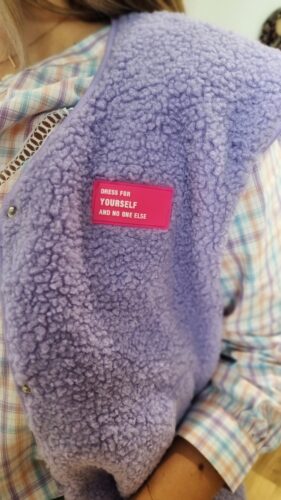 Détail du gilet sans manches femme lilas en sherpa avec patch message
